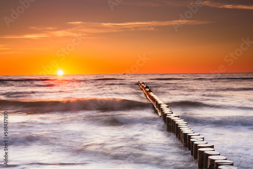 Sunset on the Baltic Sea in Rowy  Poland. Landscape with waterbreak in the sea under the sky at sunset.