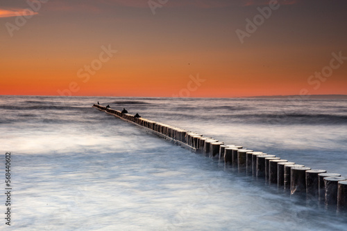 Sunset on the Baltic Sea in Rowy  Poland. Landscape with waterbreak in the sea under the sky at sunset.