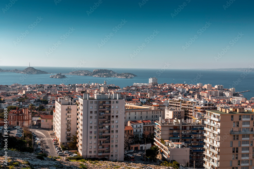 Naklejka premium Marseille, France - FEB 28, 2022: Beautiful horizon view with golden sunlight from the coast of Marseille