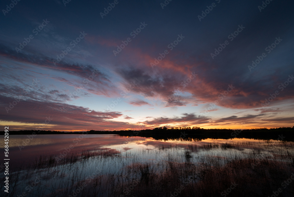 Colorful sunrise cloudscape reflected in calm water of Nine Mile Pond in Everglades National Park, Florida. Colorful sunrise cloudscape reflected in calm water of Nine Mile Pond in Everglades National Park, Florida.