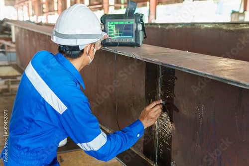 Inspectors are checking defects in welded steel h-beam add joint with process Ultrasonic testing (UT) of Non-Destructive Testing(NDT)