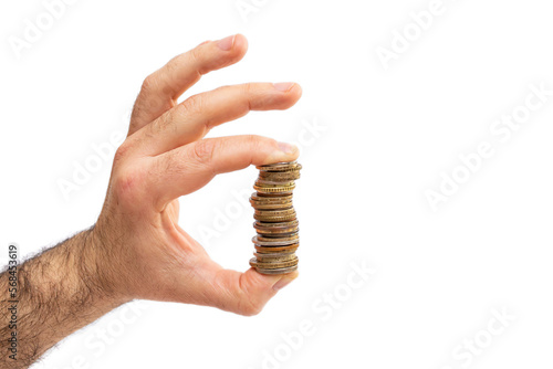 Male left hand holding a high stack of coins between thumb and index finger