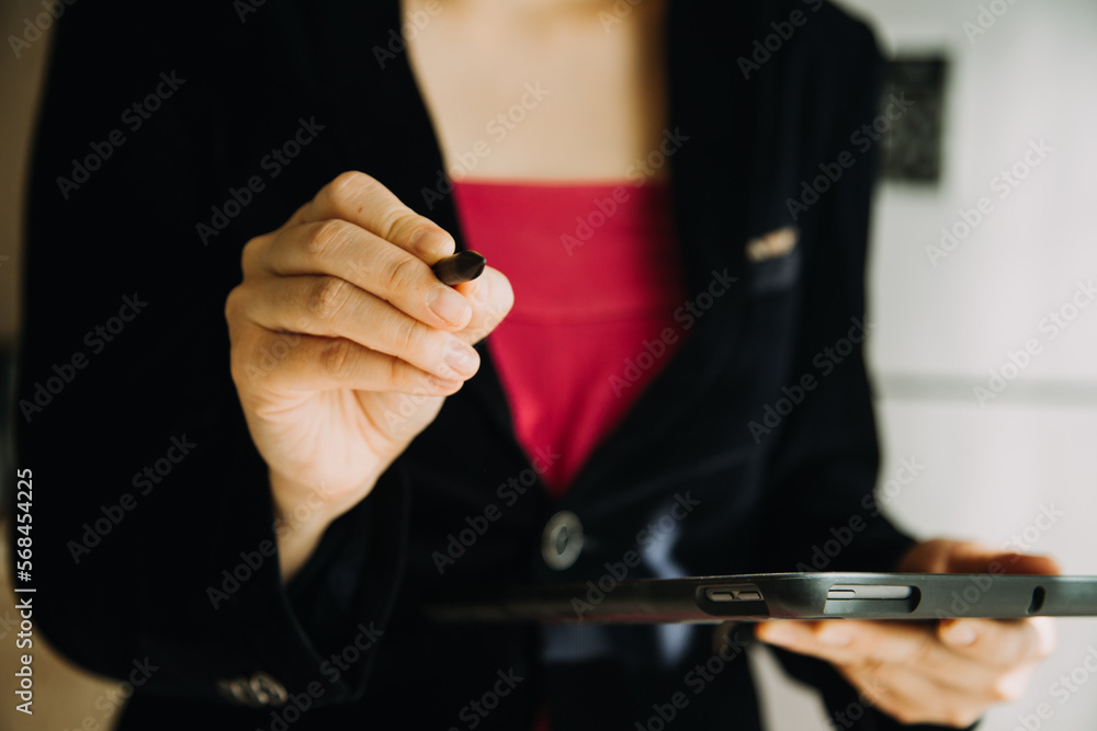Fototapeta premium Mature businessman using a digital tablet to discuss information with a younger colleague in a modern business lounge
