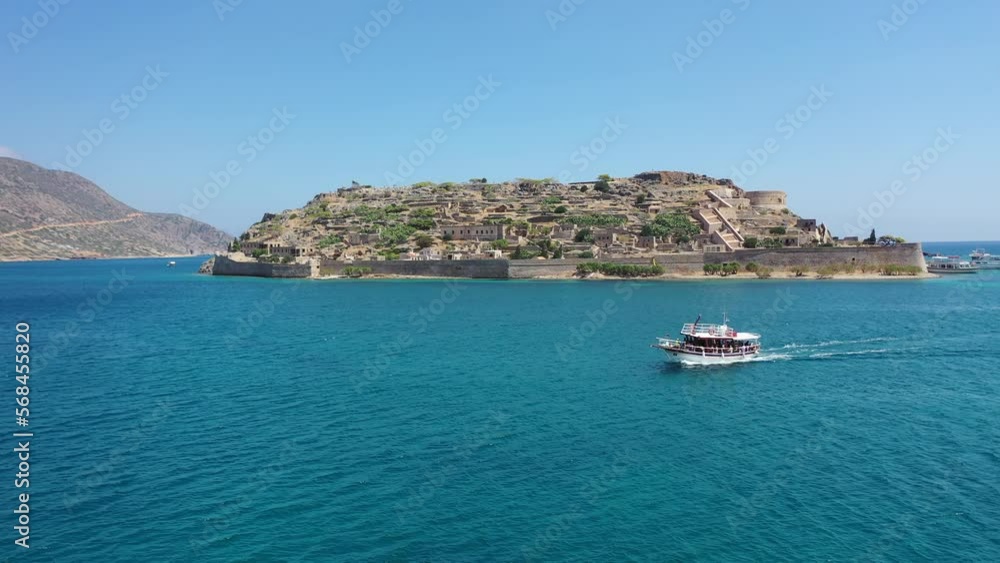 Aerial view of tourist boats on the ruins of the fortress and former leper colony island of Spingalonga (Elounda, Crete, Greece) Aerial view of tourist boats on the ruins of the fortress and former leper colony island of Spingalonga (Elounda, Crete, Greece)