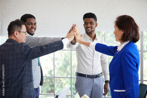 businesspeople giving high five pose and celebrating success at work in the office