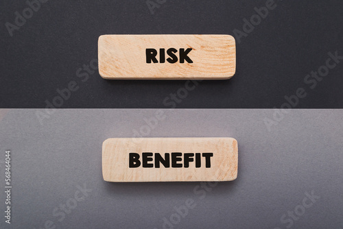 Words Risk and Benefit on board on grey and black background