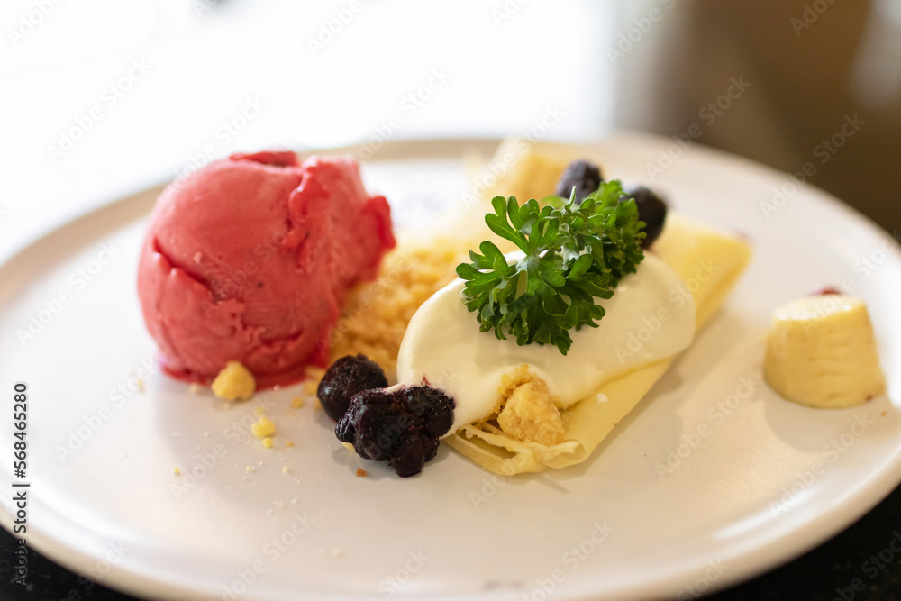 Soft crape with sorbet ice cream with berry juicy sauce and banana sliced with crumble. Soft crape with sorbet ice cream with berry juicy sauce and banana sliced with crumble.