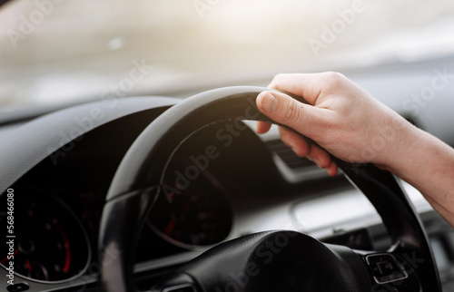 Cropped photo of arms businessman hands in classic white shirt and gold watch driving car hold wheel in new modern automobile vehicle black luxury rich salon Sale technology lifestyle concept.