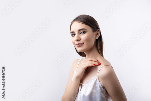 Beautiful smiling woman with clean skin, natural make-up and white teeth on a gray background