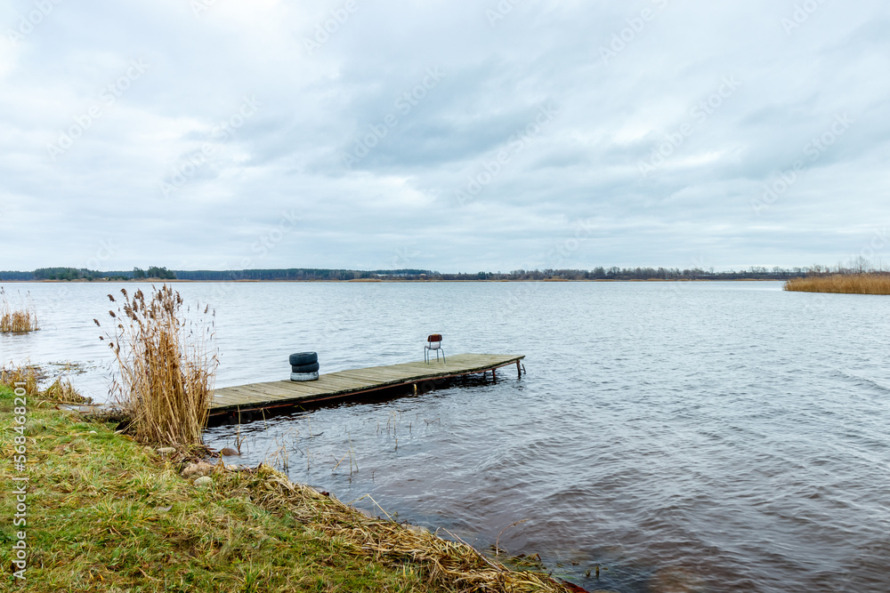 Idyllic view of a wooden pier in a lake with a cloud sky Idyllic view of a wooden pier in a lake with a cloud sky