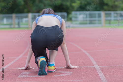 beautifull sport girl exercise at the track court and wearing blue sport bra