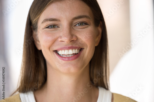 Cheerful happy beautiful young woman looking at camera, smiling, showing perfect healthy white teeth, promoting dental care, bleaching, whitening. Close up front facial portrait