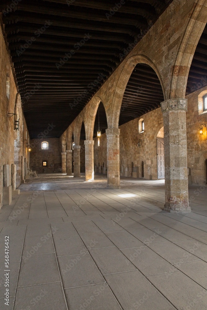 Stone arches inside building with wooden ceiling, Old Town of Rhodes, Greece.