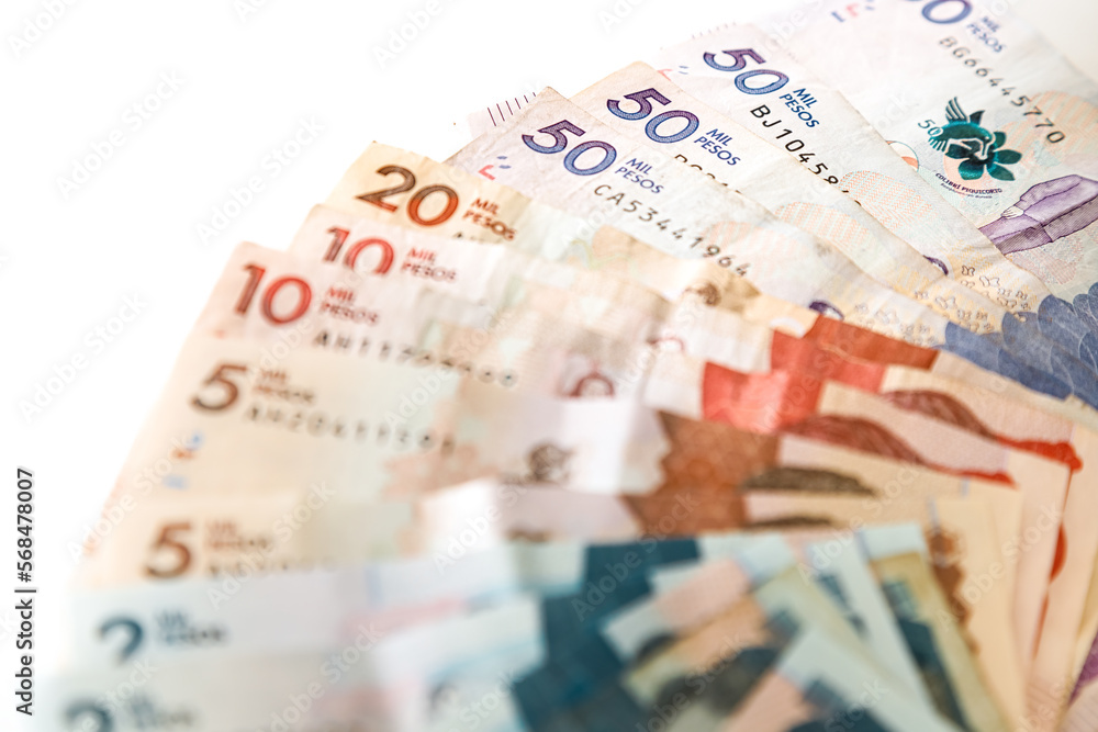Obraz premium Macro closeup of Colombian pesos of different value in the shape of a fan on a white background