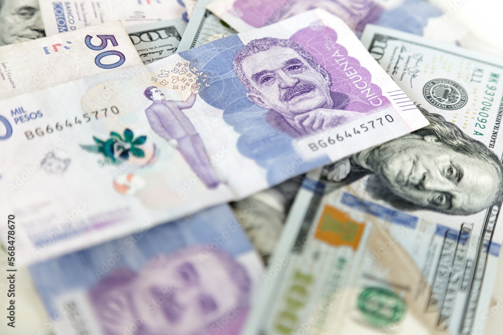 Macro closeup of 50 thousand Colombian pesos bills and 100 dollar bills Macro closeup of 50 thousand Colombian pesos bills and 100 dollar bills