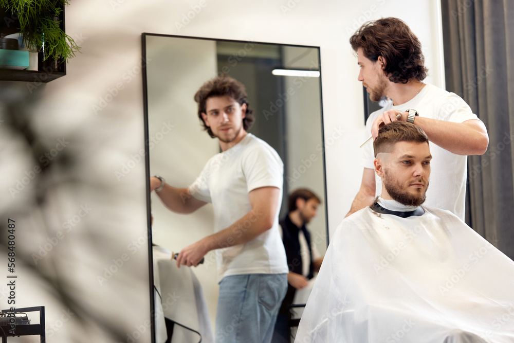Fototapeta premium man visiting professional hairstylist in barber shop