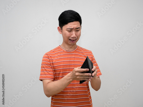Asian man orange striped shirt feels shocked about no money in wallet isolated
