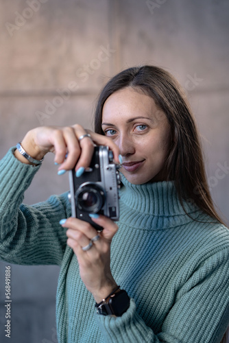 Portrait of a photographer covering her face with the camera.