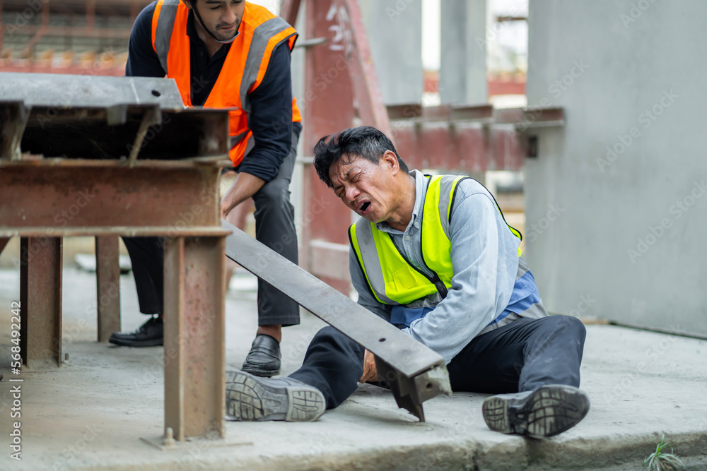 An engineer has an accident where steel falls on his leg at work, causing serious leg injuries. and get help from colleagues in the area under construction industrial factory, concept, safe work An engineer has an accident where steel falls on his leg at work, causing serious leg injuries. and get help from colleagues in the area under construction industrial factory, concept, safe work