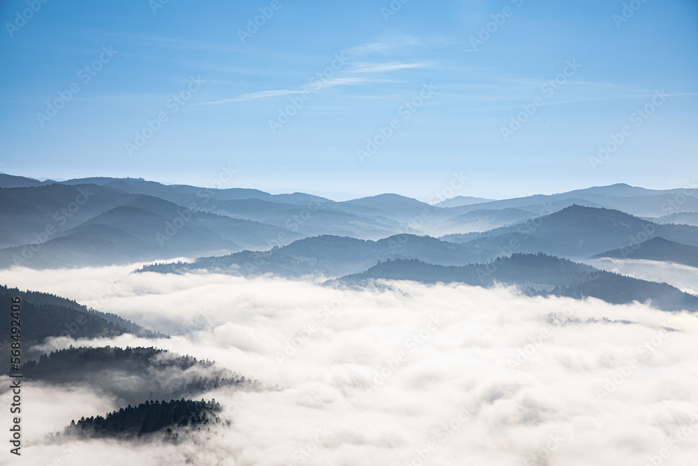 Peaks of hills emerge from behind the clouds. Poland's view from the Three Crowns