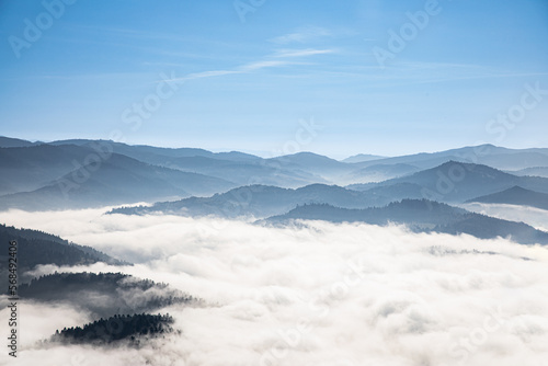 Peaks of hills emerge from behind the clouds. Poland s view from the Three Crowns