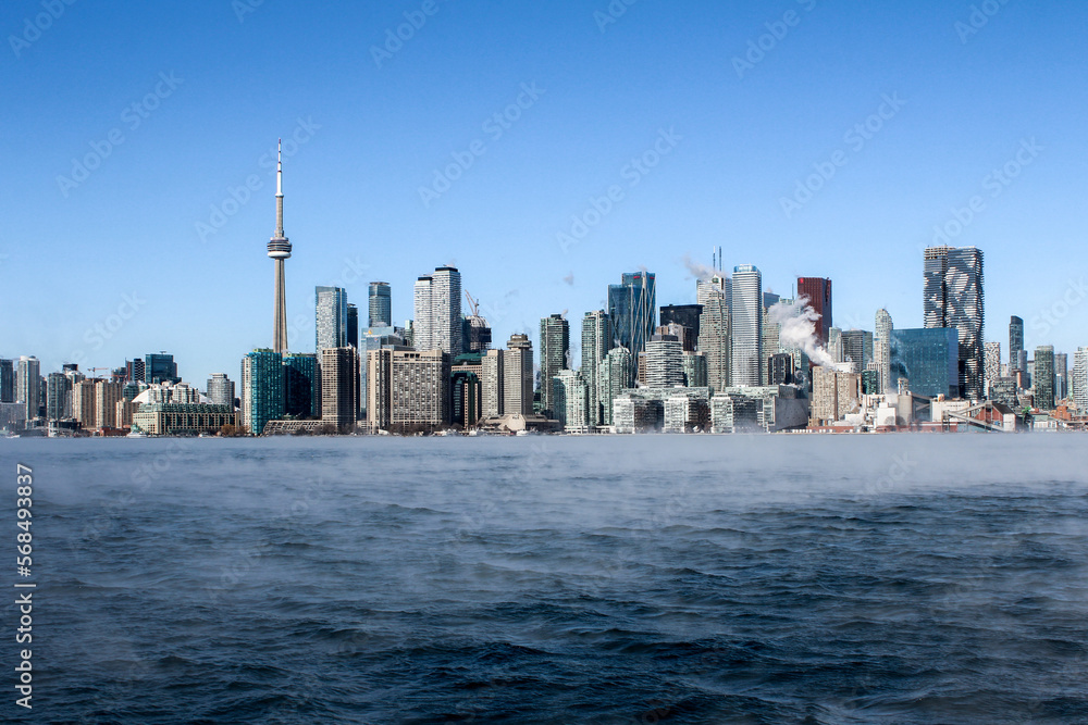 Obraz premium Cold frozen steaming lake with Toronto skyline in winter
