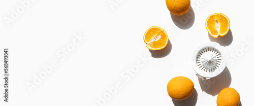 Quadro su tela Fresh oranges prepared for juicing in a hand bowl on a white background