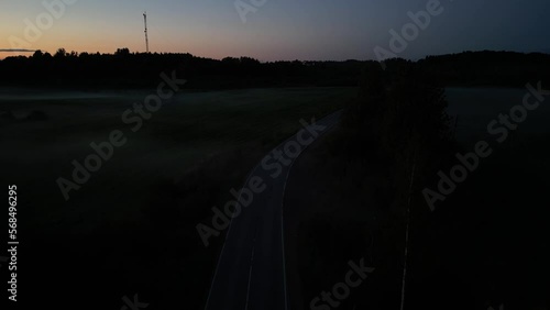 A car driving down a street at night. Drone view
