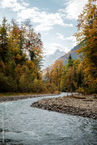 View of the river Trettach in Bavaria with mountain and forest with autumn colors in the background. photo