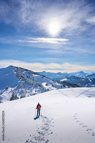 nice and active senior woman snowshoeing in deep powder snow in themountains of the Allgau alps near Balderschwang, Bavaria, Germany 