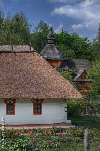 Rural house with thatched roof and old church.