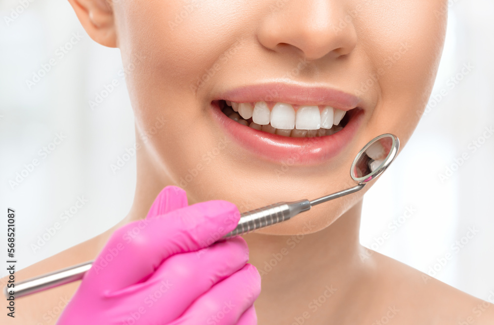 A dentist doctor treats caries on a tooth of a young beautiful woman in a dental clinic. Tooth filling. A dentist doctor treats caries on a tooth of a young beautiful woman in a dental clinic. Tooth filling.