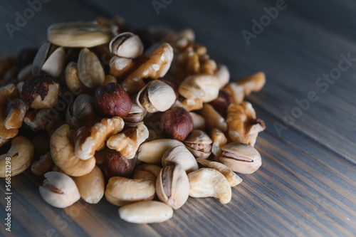 mixed nuts in a bowl on wooden table, top view with copy space.