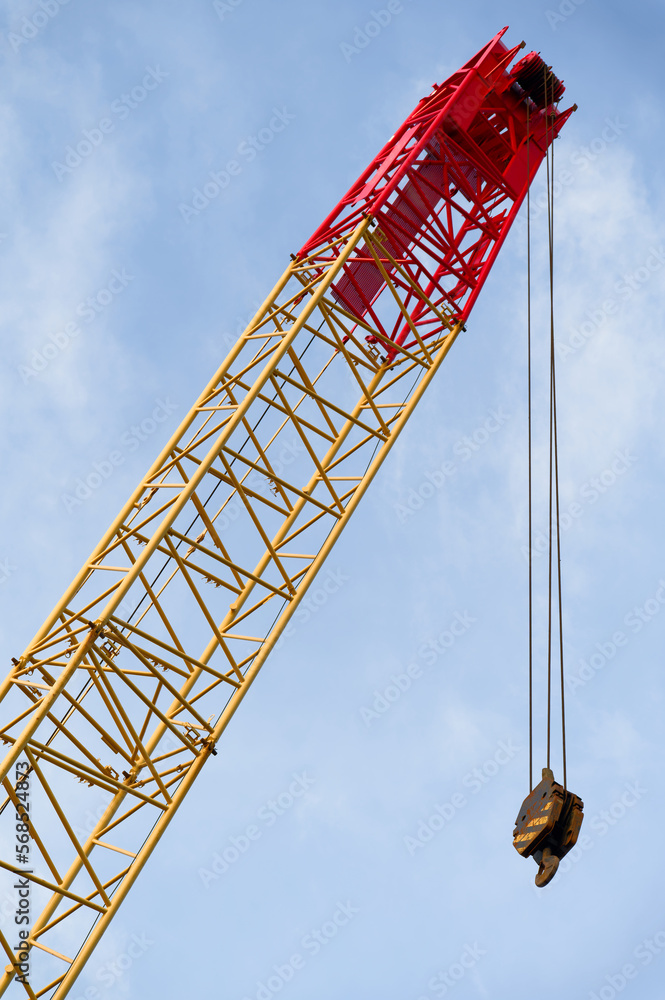 Crane and lifting hook close up against blue sky Crane and lifting hook close up against blue sky