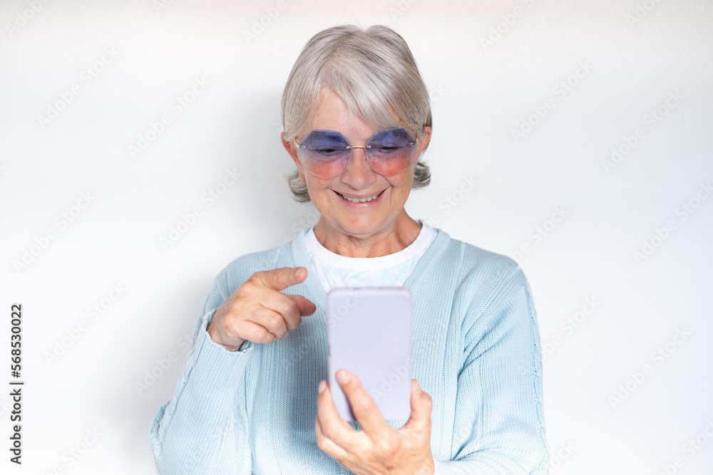 Video call concept. Senior attractive woman is using smartphone for online communication via video meeting, smiling grey-haired woman looking and talking into phone webcam Video call concept. Senior attractive woman is using smartphone for online communication via video meeting, smiling grey-haired woman looking and talking into phone webcam