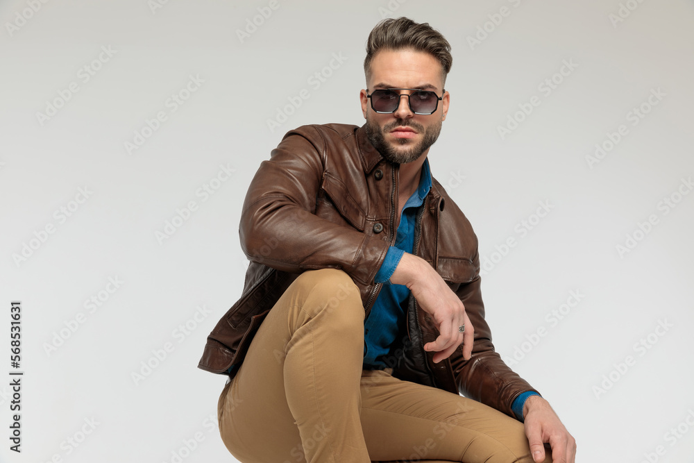 casual man resting arms, squatting with tough attitude casual man resting arms, squatting with tough attitude