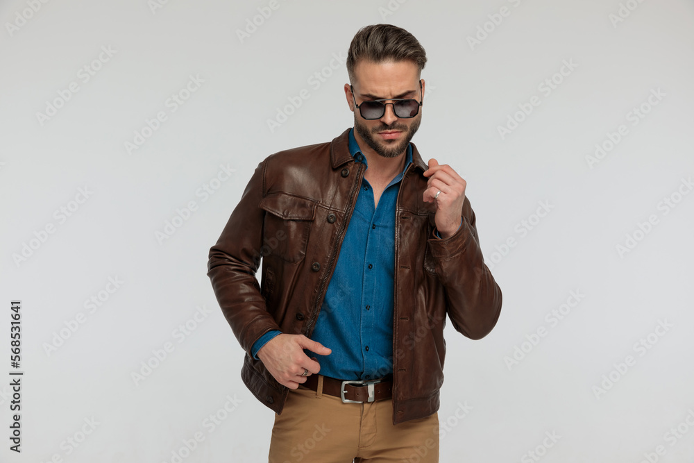 casual man looking down and adjusting his jacket casual man looking down and adjusting his jacket