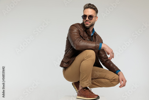 Quadro em tela casual man resting arms, squatting and looking away