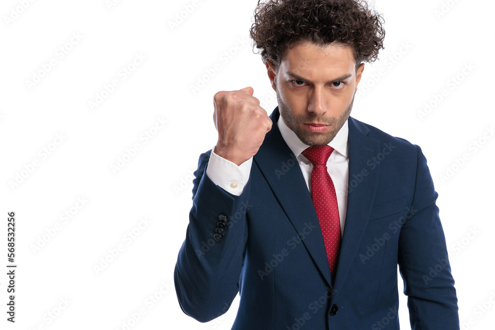 upset young bussinessman showing fist and threatening upset young bussinessman showing fist and threatening