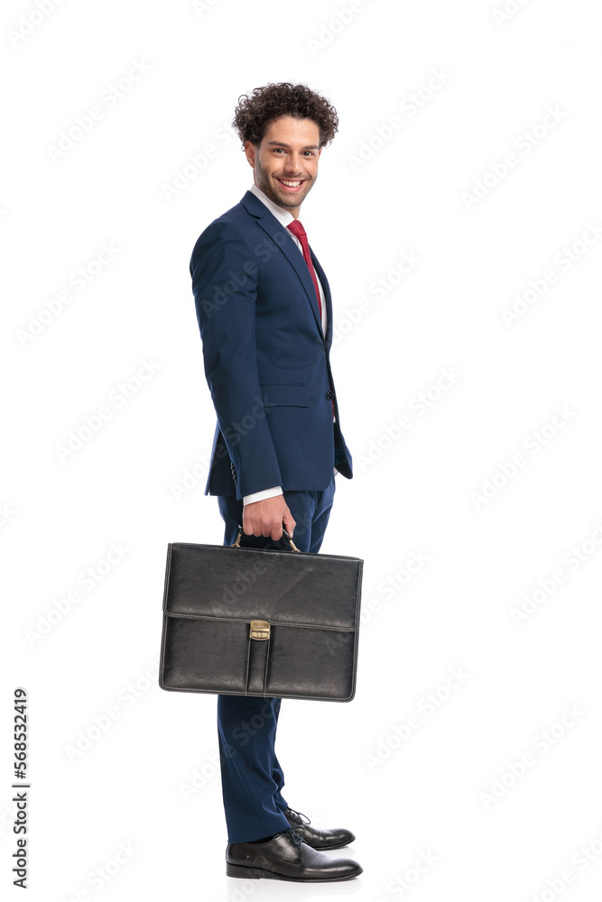 side view of happy elegant businessman holding suitcase and smiling side view of happy elegant businessman holding suitcase and smiling