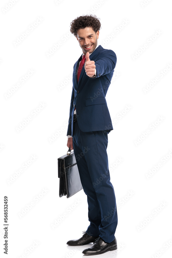 happy elegant businessman smiling, holding suitcase and making thumbs up gesture happy elegant businessman smiling, holding suitcase and making thumbs up gesture