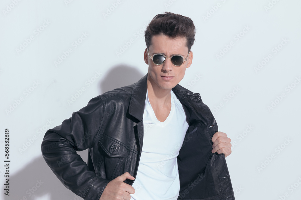 casual man with macho style is pulling his leather jacket casual man with macho style is pulling his leather jacket