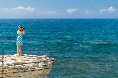 Girl photographer takes a picture of the sea