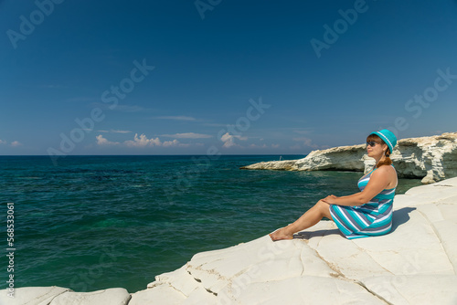 A young pretty girl is resting on the shores of the azure sea