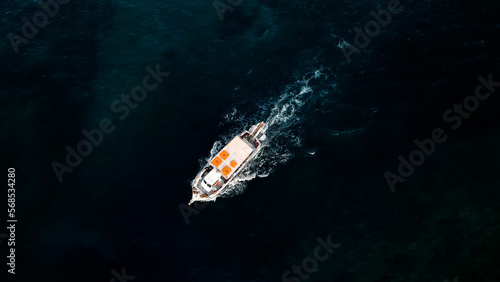 Aerial view of little white boat sailing at deep sea water