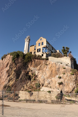 Ruins sitting on top of a cliff, built on a steep hill, viewed from the ocean. photo