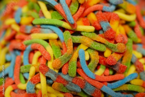 delicious  jelly  multi-colored sweets  lie on the table. a lot of colored  sweet candies  a background of many green  blue  yellow  pink  cyan  white  black  red candies of various shapes