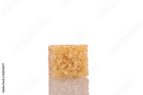 One cube of brown sugar, close-up, isolated on white.