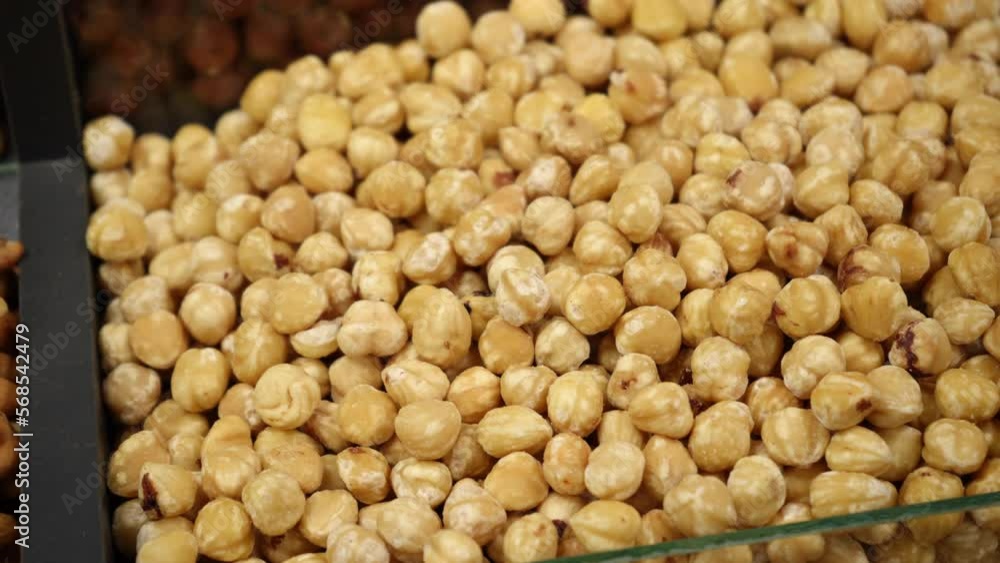 Peeled roasted hazelnuts close-up on the store counter. Hazelnut close-up. Panorama. Peeled roasted hazelnuts close-up on the store counter. Hazelnut close-up. Panorama.