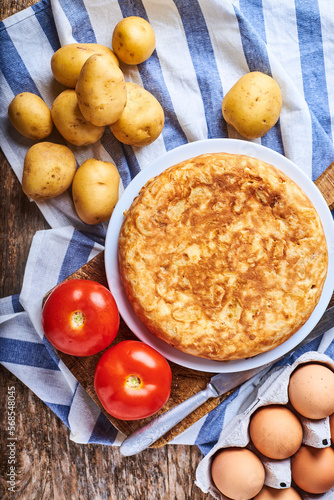 Obraz na płótnie Tortilla de patatas con sus ingredientes recien hecha y casera en una imagen cenital. w salonie